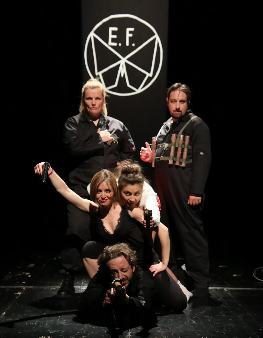 Grupa glumaca u crnim kostimima na pozornici