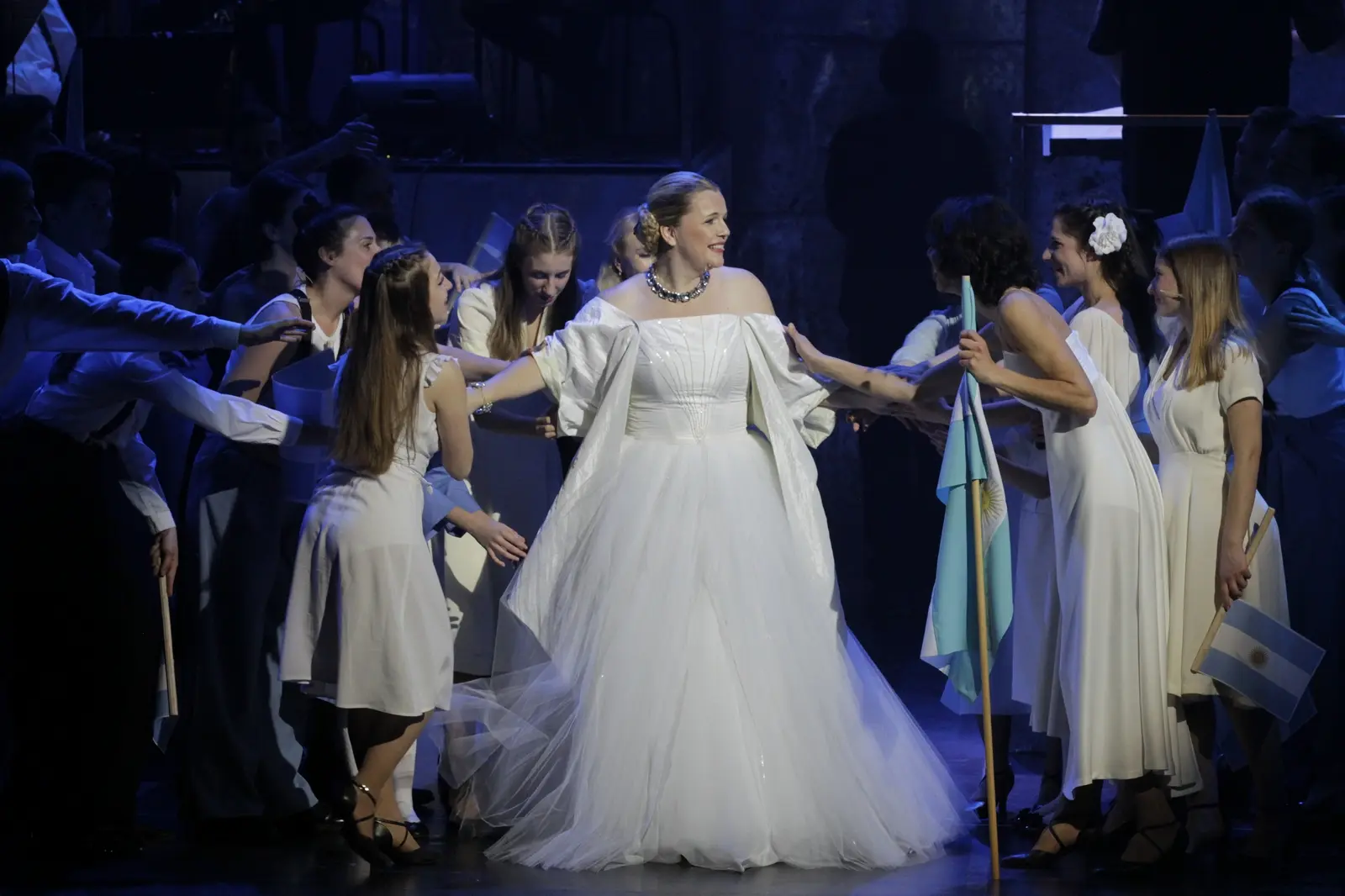 Leonora Surian u bijeloj haljini okružena plesačima u sceni iz predstave 'Evita'