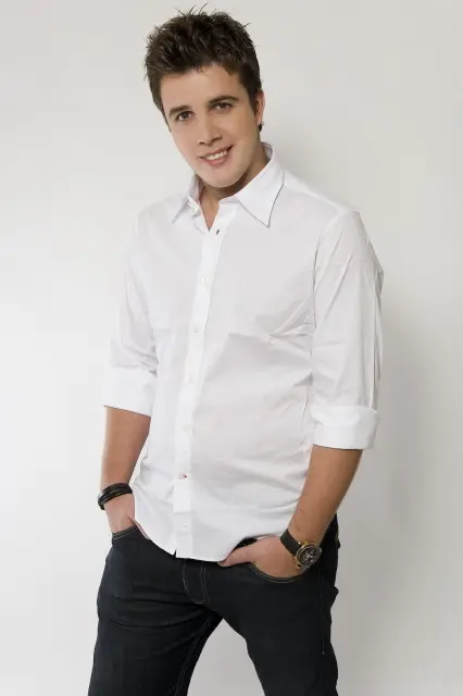 Portret mlađeg muškarca, Gia Suriana Jr., u bijeloj košulji, nasmijan, s rukama u džepovima.