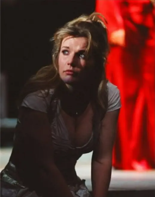 Glumica u sceni iz predstave, sjedi na podu