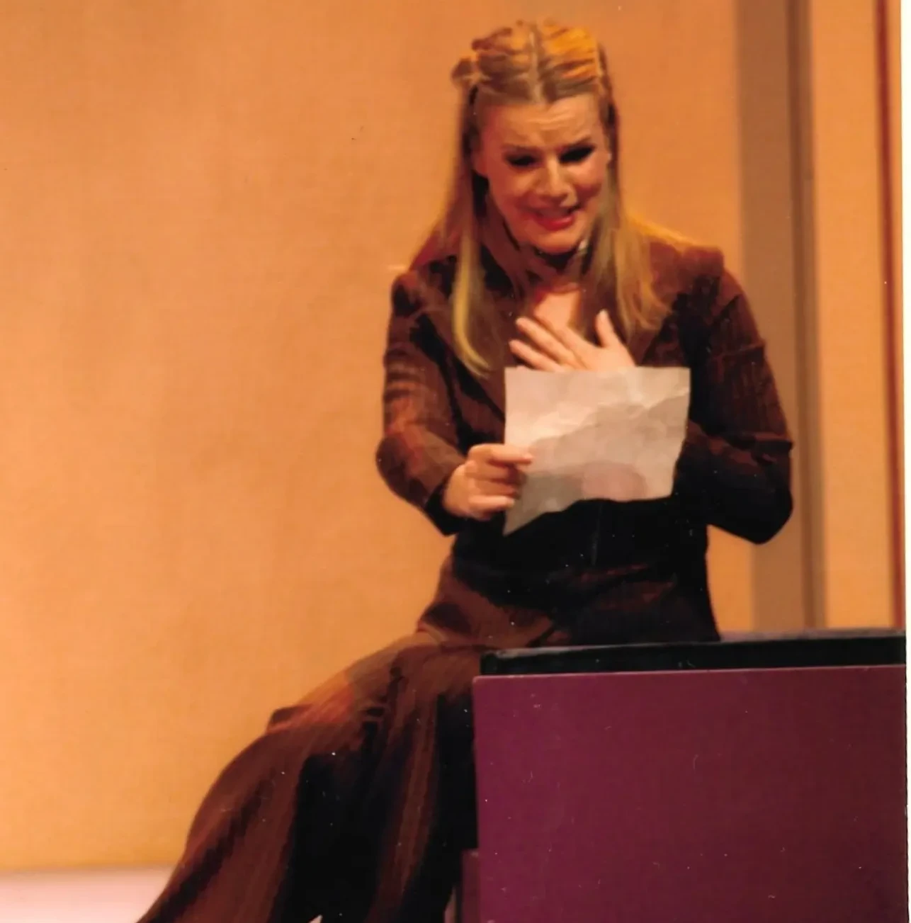 Leonora Surian u sceni iz predstave, drži pismo i izgleda zabrinuto