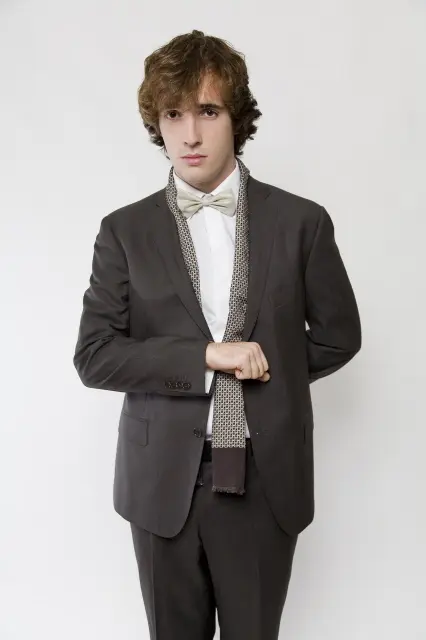 Portret Stefana Suriana, glumca, u elegantnom odijelu s bijelom košuljom i leptir mašnom.