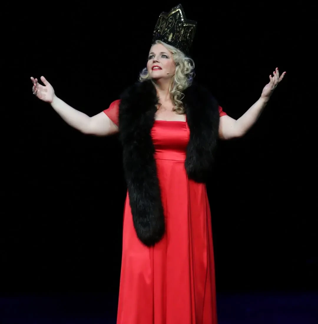 Leonora Surian u crvenoj haljini i s krunom u sceni iz predstave
