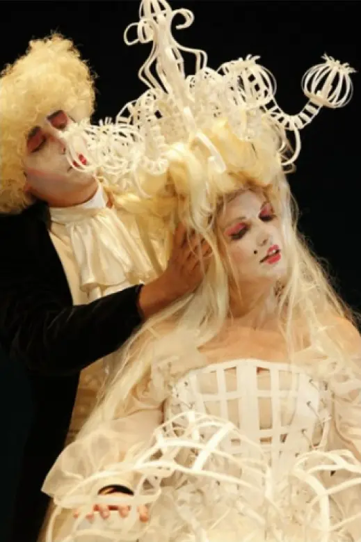 Leonora Surian u bijelom kostimu s visokim ukrasom na glavi u sceni iz predstave